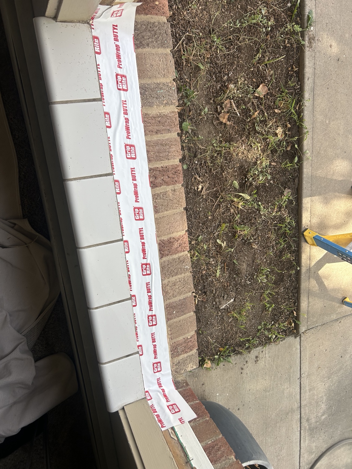 Weather barrier applied along the brick window opening during installation