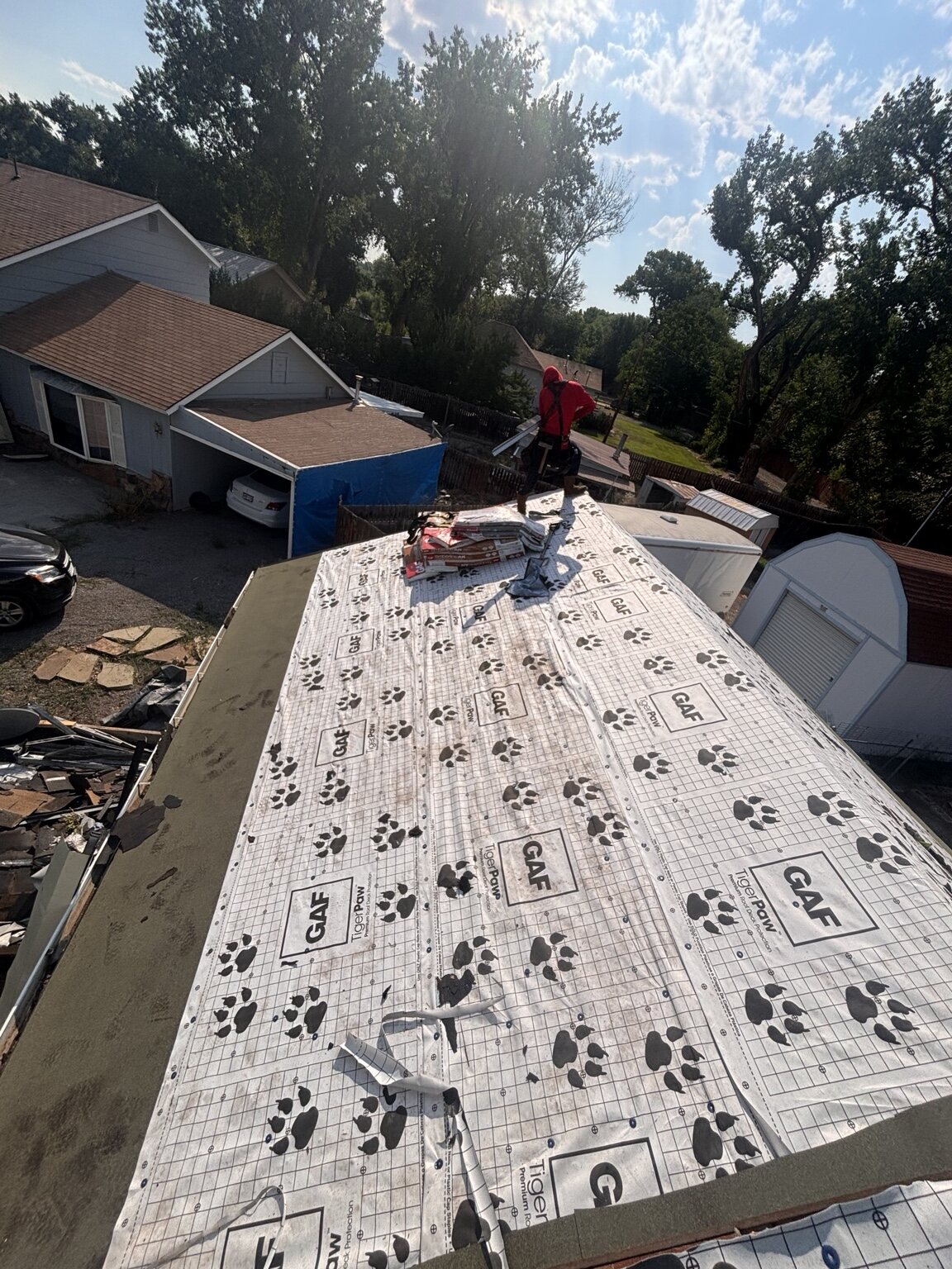 Roofing crew installing synthetic underlayment
